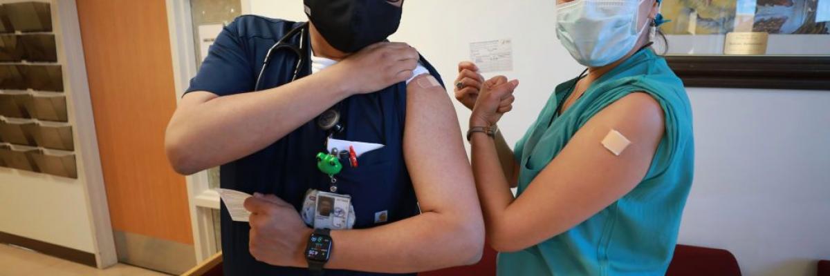 A Navajo doctor and patient pose for photos after receiving their COVID-19 vaccines at Northern Navajo Medical Center on December 15, 2020 in Shiprock, New Mexico. (Micah Garen/Getty Images)