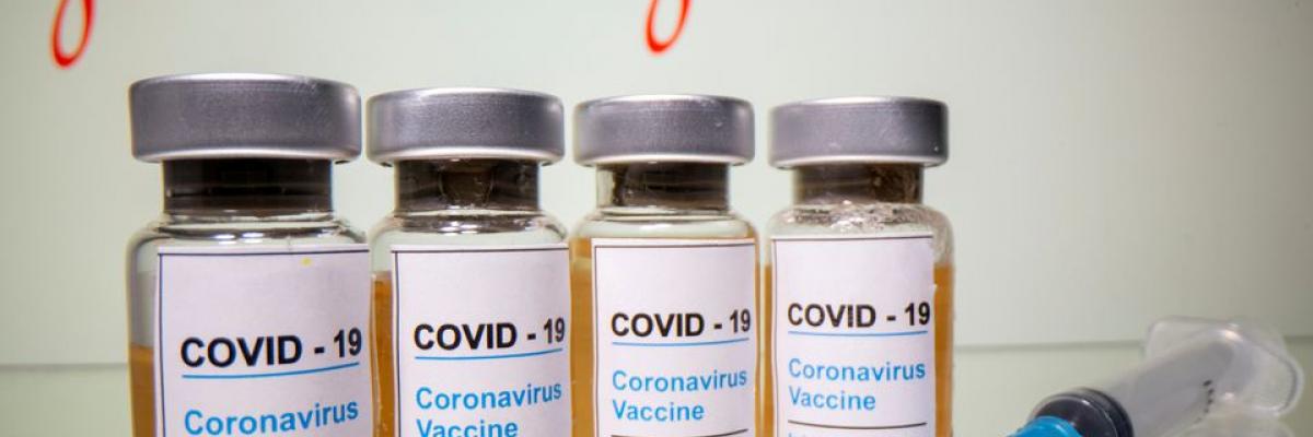 Vials with a sticker reading, "COVID-19 / Coronavirus vaccine / Injection only" and a medical syringe are seen in front of a displayed Johnson & Johnson logo in this illustration taken October 31, 2020. REUTERS/Dado Ruvic/Illustration