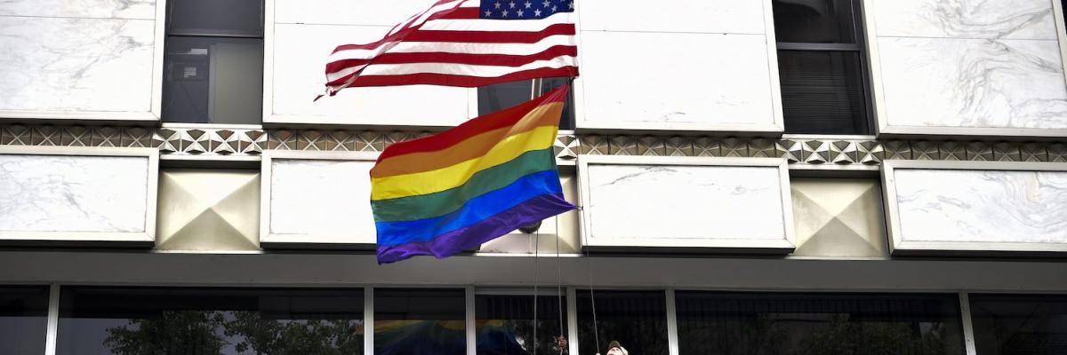 A U.S. Marine raises the U.S. flag and Pride flag to half-mast, following a mass shooting at an Orlando nightclub, at the U.S. Embassy in Mexico City on June 13, 2016. YURI CORTEZ/AFP VIA GETTY IMAGES