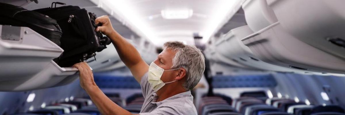  In this May 28, 2020, file photo, a passenger wears personal protective equipment on a Delta Airlines flight after landing at Minneapolis−Saint Paul International Airport in Minneapolis. (AP Photo/John Minchillo, File)