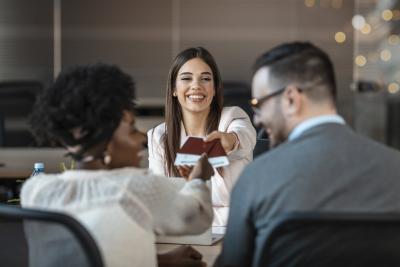 Travel agent giving tickets and passport with visa to tourists. (Photo via dragana991 / iStock / Getty Images Plus)