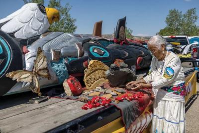 Rose Yazzie, 80, rests her hands on the 25-foot totem pole Sunday morning at Counselor Chapter House. Photo by Sharon Chischilly, Navajo Times.