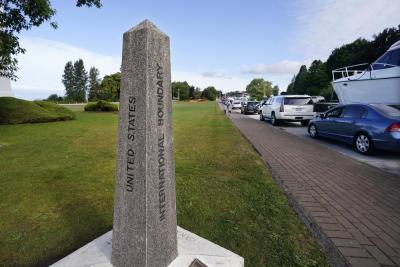 A line of vehicles wait to enter Canada at the Peace Arch border crossing Monday, Aug. 9, 2021, in Blaine, Wash. Canada lifted its prohibition on Americans crossing the border to shop, vacation or visit, but America kept similar restrictions in place, part of a bumpy return to normalcy from coronavirus travel bans. (AP Photo/Elaine Thompson)