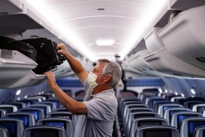 In this May 28, 2020, file photo, a passenger wears personal protective equipment on a Delta Airlines flight after landing at Minneapolis−Saint Paul International Airport in Minneapolis. (AP Photo/John Minchillo, File)