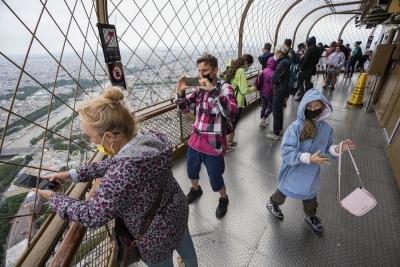 In this Friday, July 16, 2021 file photo, visitors enjoy the view from top of the Eiffel Tower in Paris. The European Union is expected to recommend that its member states reinstate restrictions on tourists from the U.S. because of rising coronavirus infection levels in the country, EU diplomats said Monday, Aug. 30. (AP Photo/Michel Euler, File)