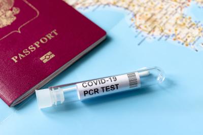 COVID-19, travel and test concept, tube for PCR testing and tourist passport on geographic map. Coronavirus diagnostics in airport due to pandemic. Tourism and business hit by SARS-Cov-2 corona virus. Photo by scaliger