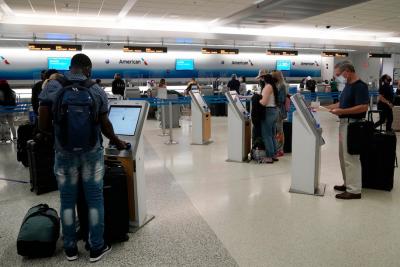Travelers use self-service kiosks to check in at the American Airlines terminal in Miami. (Marta Lavandier/AP)