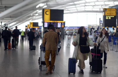 Passengers walk with their luggage through Heathrow airport in London on June 1. (Reuters/Hannah McKay)