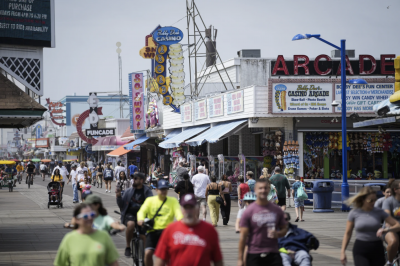 Visitors stroll past arcades on the boardwalk in Wildwood, N.J., Friday, August 9, 2024. (AP Photo/Matt Rourke)