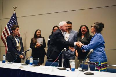 Vice Presidential candidate and Minnesota Gov. Tim Walz shakes hands with panelists during the Native American Caucus meeting at McCormick Place in Chicago on Aug. 19, 2024. Grace Widyatmadja/NPR