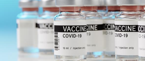 Ampoules with Covid-19 vaccine on a laboratory bench. Photo by M.Rode-Foto