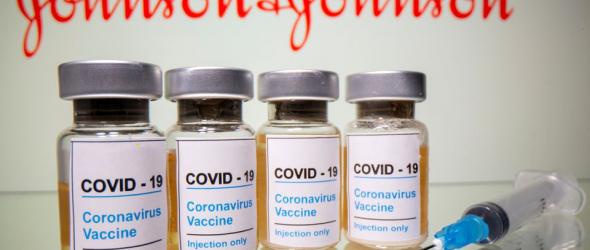 Vials with a sticker reading, "COVID-19 / Coronavirus vaccine / Injection only" and a medical syringe are seen in front of a displayed Johnson & Johnson logo in this illustration taken October 31, 2020. REUTERS/Dado Ruvic/Illustration