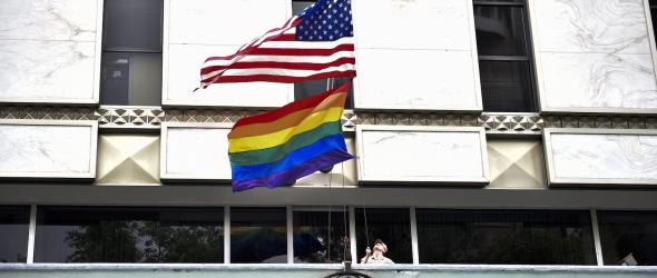 A U.S. Marine raises the U.S. flag and Pride flag to half-mast, following a mass shooting at an Orlando nightclub, at the U.S. Embassy in Mexico City on June 13, 2016. YURI CORTEZ/AFP VIA GETTY IMAGES