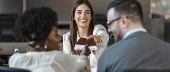 Travel agent giving tickets and passport with visa to tourists. (Photo via dragana991 / iStock / Getty Images Plus)