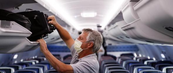  In this May 28, 2020, file photo, a passenger wears personal protective equipment on a Delta Airlines flight after landing at Minneapolis−Saint Paul International Airport in Minneapolis. (AP Photo/John Minchillo, File)