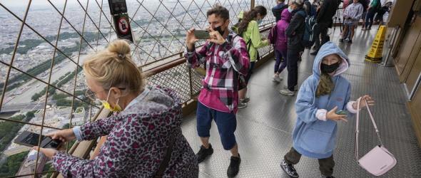 In this Friday, July 16, 2021 file photo, visitors enjoy the view from top of the Eiffel Tower in Paris. The European Union is expected to recommend that its member states reinstate restrictions on tourists from the U.S. because of rising coronavirus infection levels in the country, EU diplomats said Monday, Aug. 30. (AP Photo/Michel Euler, File)