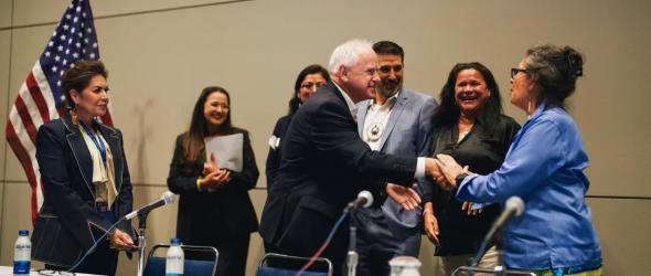 Vice Presidential candidate and Minnesota Gov. Tim Walz shakes hands with panelists during the Native American Caucus meeting at McCormick Place in Chicago on Aug. 19, 2024. Grace Widyatmadja/NPR